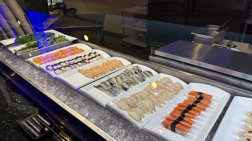 Buffet trays filled with seafood and hot dishes.